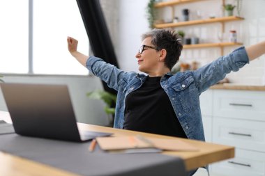 Olgun bir kadın iş yerinde mola verir, gerinir..