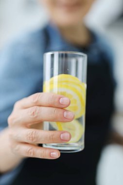 Yakından, elinde limon suyu olan bir bardak..