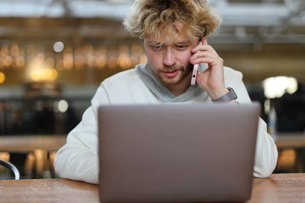 Hombre Pelo Rizado Joven Concentrado Lugar Trabajo Hablando Por Teléfono —  Fotos de Stock