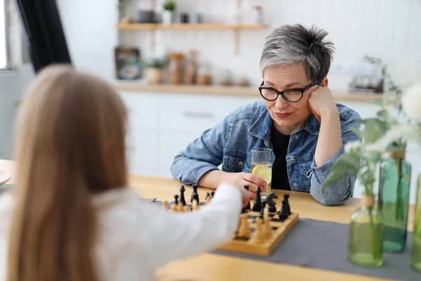 Μια Γυναίκα Σκέφτηκε Ενώ Έπαιζε Σκάκι Ένα Παιδί Στην Κουζίνα — Φωτογραφία Αρχείου