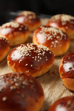 Fresh hot sweet buns with sesame seeds from the oven, homemade bakery.