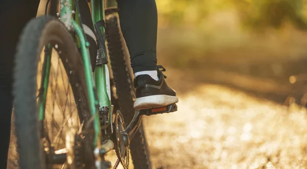 骑在森林或公园小径上的自行车踏板上的女足 — 图库照片