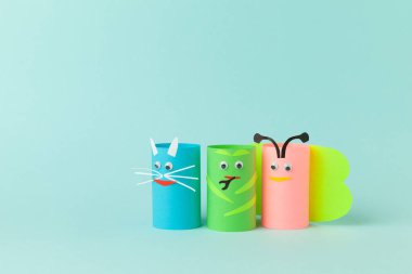 Mavi arka plandaki kağıt rulolarından ev yapımı hayvan figürleri. Yaratıcı çocuk oyuncakları, sıfır israf. Metin için alanı kopyala.