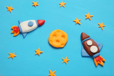 Creative craft plasticine rocket in open space, astronaut dreams. Stars, moon. Cartoon art.