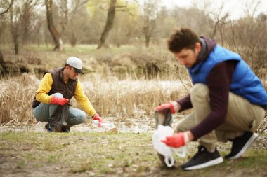 Bağış gönüllüleri ormandaki çöpleri topluyor, doğayla ilgileniyor. Parkta bahar temizliği, çöpler ve çöpler..