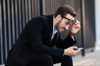 Telefonu olan genç sakallı adam beklenmedik haberler karşısında afalladı. Şok tepkisi, sürpriz.