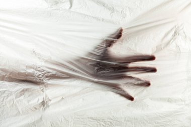 Plastik atık gezegeninin arka planında insan eli var. Plastik ambalaj ve poşet kullanımını durdurun..