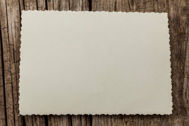 Ahşap arka planda eski model fotoğraf şablonu. Boş retro kart, desenli kağıt.