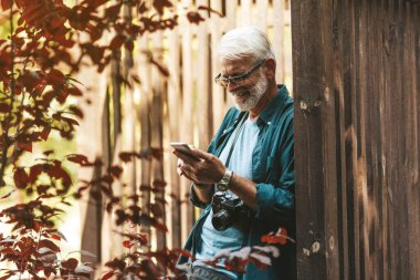 Sakallı olgun bir adam flört servisini kullanıyor ve gülümsüyor. İnternette bir aşk partneri arıyorum. Yeni arkadaşlarla mesajlaşıyorum. Film tahılı.