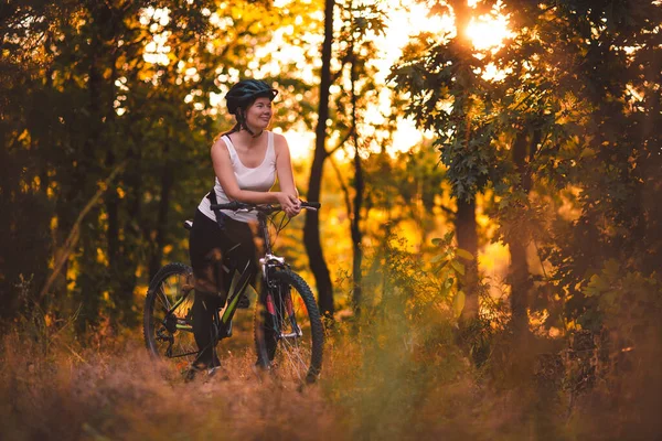 早上骑自行车在公园里 一个女人在树间升起的阳光中 电影及谷物 — 图库照片