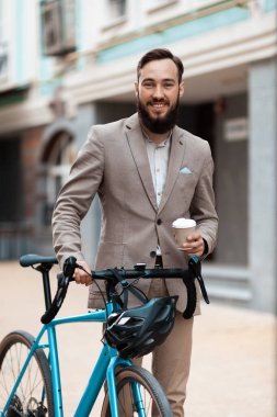 İşe bisikletle gidiyorum. Şehir caddesinde bisikleti olan takım elbiseli bir adam. Kişisel ekolojik taşıma.