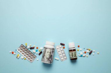 Pills and one hundred dollar bill. Dependence on drugs. Pharmaceutical industry, earnings on sick people.