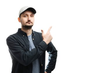 Sakallı ve şapkalı modaya uygun beyaz adam mesaj için boş alanda parmak gösteriyor. Şuraya bak, işaret ediyor..