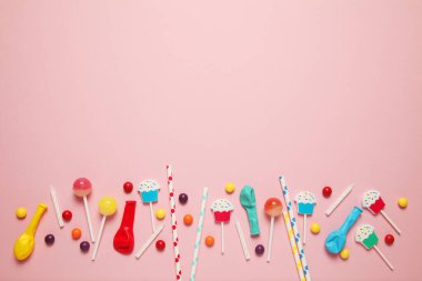 Çocuk tatilinin şenlikli arka planı (şablon). Pembe arka planda tatlılar olan neşeli bir doğum günü partisi.