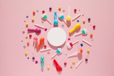 Çocukların doğum günü pembe arka planı. Dağınık renkli şekerler, toplar, mumlar ve pipetler.