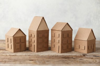 Tahta arka planda mukavva oyuncak evler. Satış ya da kiralık konut. Evdeki komşular. Banliyöde rahat bir hayat.