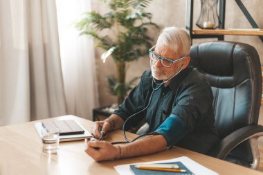 Yüksek tansiyon riski. Yaşlı adam kan basıncını evde bir tonometreyle ölçer. Kalp ve damar hastalıklarının önlenmesi ve teşhisi.