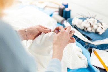 Giysi tamiri. El dikimi, kumaşla çalışan terzi..