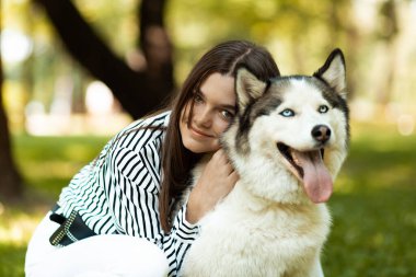 Sahibi ve evcil hayvanı. Temiz havadaki hayvanlarla dinlenin. Kız kabuğuna sarılıyor.