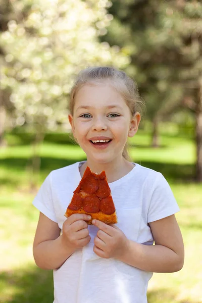 Lächelndes Kindermädchen Mit Einem Stück Pizza Mittagessen Der Natur Stockfoto