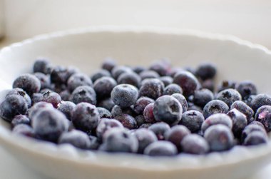Açık arkaplanda donmuş yaban mersini tabağı