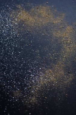 Siyah arka planda küçük cam tuzluk ve biber karıştırıcı. Dağınık tuz ve biber.