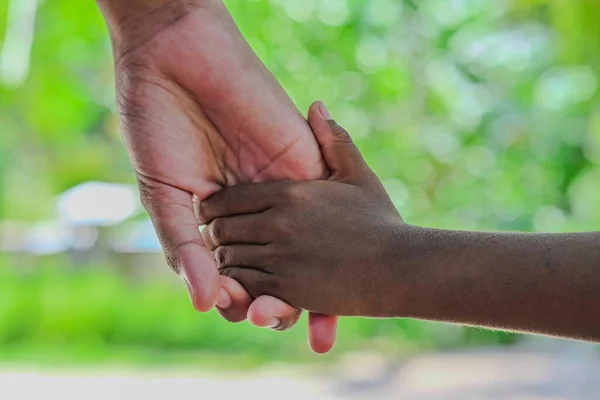 close - up of two hands holding the other child \'s hand