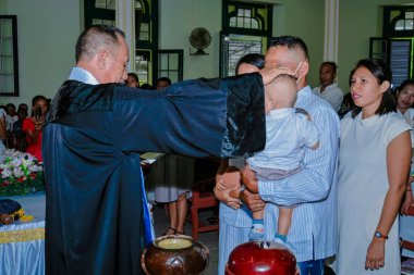 Maluku, Endonezya - 26 Aralık 2020: Kilisede bir çocuk vaftiz edildi