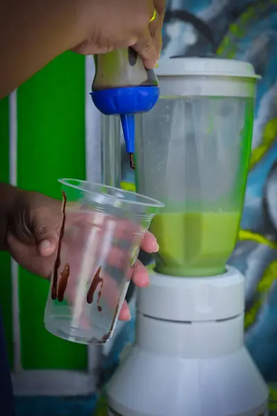 close up of woman\'s hand pouring juice into cup