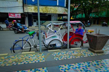 Ambon, Indonesia - February 23, 2020: Pedicab parked on the side of the road clipart