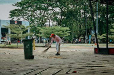 Ambon, Endonezya - 29 Eylül 2022: Bir hademe şehir parkını temizliyor