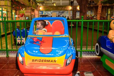 Ambon, Endonezya - 12 Nisan 2013: lunaparktaki oyuncak bir arabada bir çocuk