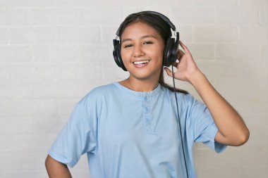 Bir kız müzik dinlemek için kulaklık takıyor.