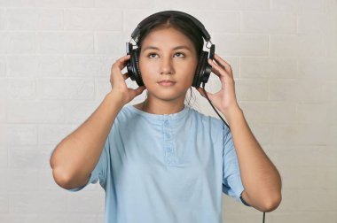 Bir kız müzik dinlemek için kulaklık takıyor.