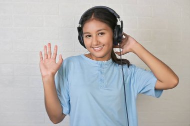 Bir kız müzik dinlemek için kulaklık takıyor.