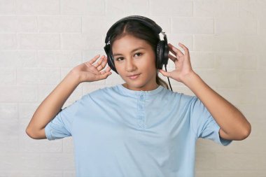 Bir kız müzik dinlemek için kulaklık takıyor.