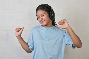 Bir kız müzik dinlemek için kulaklık takıyor.