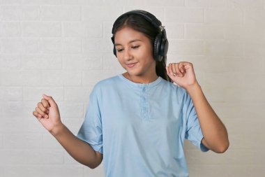 Bir kız müzik dinlemek için kulaklık takıyor.