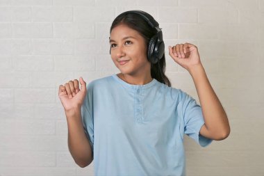 Bir kız müzik dinlemek için kulaklık takıyor.