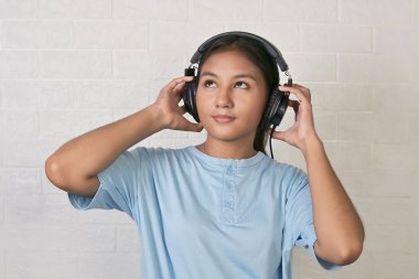 Bir kız müzik dinlemek için kulaklık takıyor.