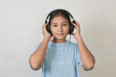 Bir kız müzik dinlemek için kulaklık takıyor.