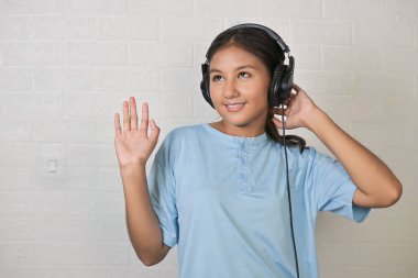 Bir kız müzik dinlemek için kulaklık takıyor.