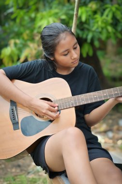 Parkta gitar çalan mutlu kız.