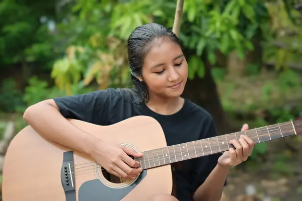 Parkta gitar çalan mutlu kız.