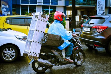 Ambon, Endonezya - 4 Nisan 2024: Merdiven taşıyan motosiklet