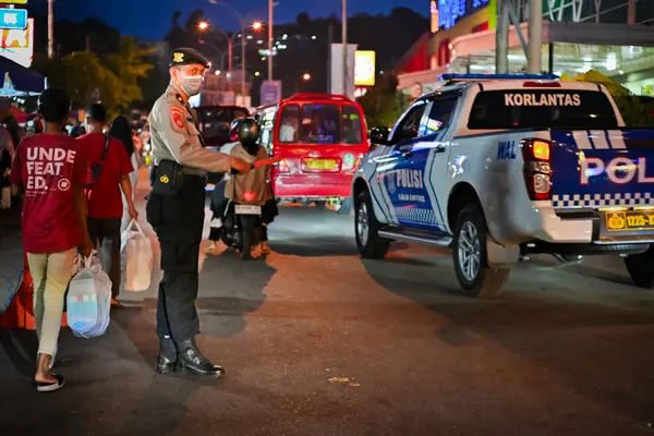 Ambon, Endonezya - 7 Nisan 2024: Polis otoyolda trafik akışını yönlendiriyor