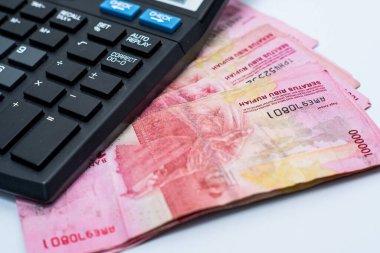 Endonezya - 23 Mayıs 2024: Yüz bin rupia değerinde Endonezya parası hesap makinesi ile yan yana