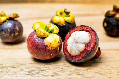 Ahşap arka planda izole edilmiş mangosteen meyvesi. Mangosteen çok yüksek seviyede antioksidan içeren bir meyve olarak bilinir. Sarsinya mangostana