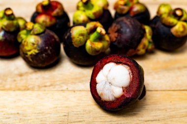 Ahşap arka planda izole edilmiş mangosteen meyvesi. Mangosteen çok yüksek seviyede antioksidan içeren bir meyve olarak bilinir. Sarsinya mangostana
