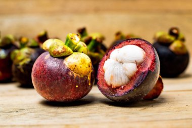 Ahşap arka planda izole edilmiş mangosteen meyvesi. Mangosteen çok yüksek seviyede antioksidan içeren bir meyve olarak bilinir. Sarsinya mangostana